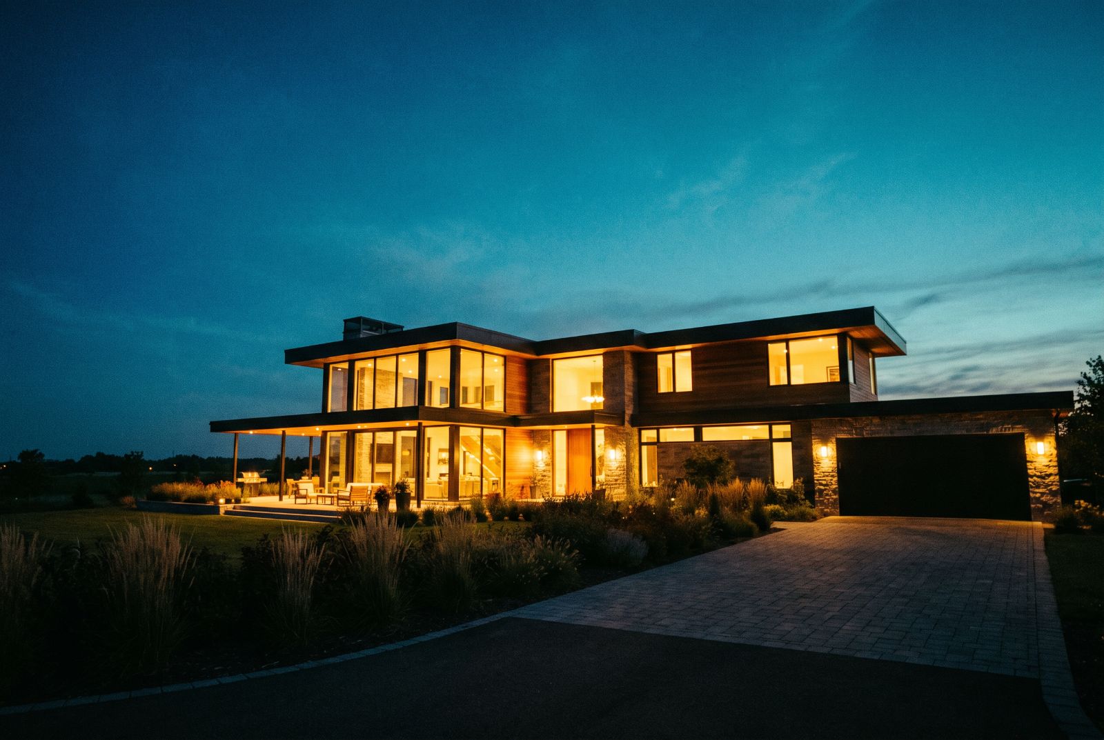 Modern house exterior at dusk with warm window light